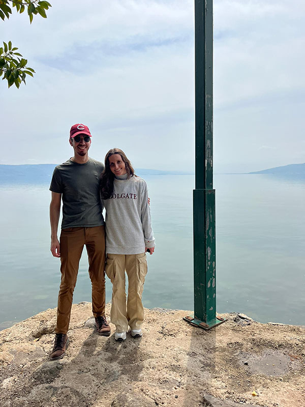 Matthew Carusi ’21 and Kyra Conciatori ’17 posing for photo on the shore of the Sea of Galilee