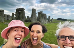 Three alumni pose for photo at Stonehenge
