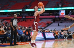 Colgate basketball player Tucker Richardson shoots a three pointer as fans watch the game.