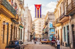 Cuban street scene with national flag hanging across