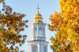 Chapel spire flanked by fall foliage