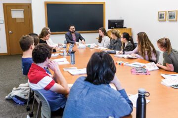 Students around a conference table with Javier Padilla Rios, Assistant Professor of English at Colgate