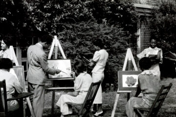 Black and white image of Black artists painting at easels outdoors