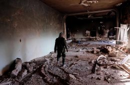A member of a Christian armed militia Sutoro walks among ruins of a Sufi shrine belonging to Sheikh Khaznawi blown apart by ISIS in Tel Marouf or Tal (Credit: Eddie Gerald / Alamy Stock Photo)
