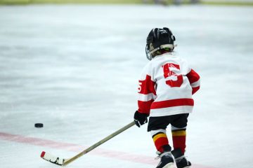 child wearing hockey gear skates in rink