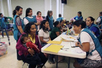 Refugee families and response team members sit at tables
