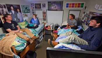 Students sitting on beds, talking, in Curtis Hall