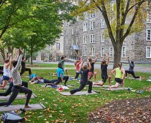 Yoga class in lunge position on the residential quad