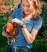 Student holding a chicken and smiling