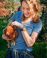 Student holding a chicken and smiling