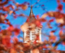 Cupola on campus seen through out-of-focus red fall foliage