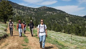 Students walk along a sunny Colorado trail