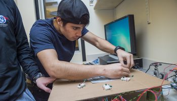 Anthony Castillo ’19, an astrophysics major from Los Angeles, adjusts a switch on his Whack-A-Mole project