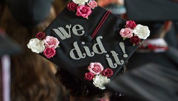 "We did it!" on a decorated graduation cap