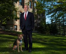 President Casey outside James B. Colgate Hall with his dog, Emrys.