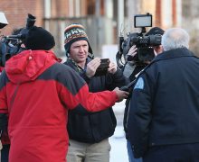 Reporter Joel Currier ’00 records an outdoor interview with police