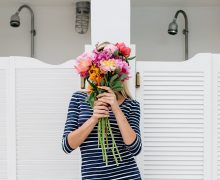 woman holding flower bouquet in front of her face