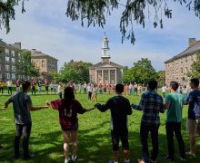 Students hold hands on the Academic Quad in an activity to get to know one another