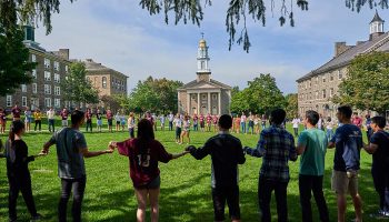 Students hold hands on the Academic Quad in an activity to get to know one another