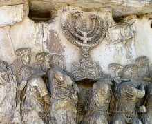 Stone relief of people carrying menorah