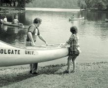 Two Colgate students launching a canoe