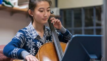 Smiling student playing cello