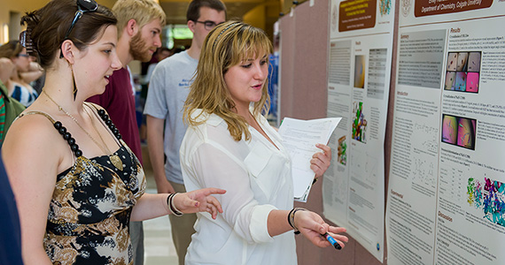 Emily Rundlet '14 (right) discusses her research at a recent poster session at the Ho Science Center. (Photo by Andy Daddio)