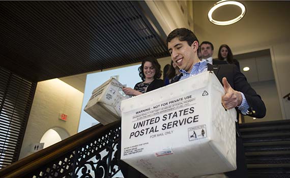 Members of the Colgate Office of Admission carry loads of acceptance letters to the mail room for delivery Tuesday. (Photo by Duy Trinh)