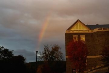 Shot of a Colgate building with a rainbow.