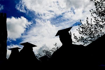 Silhouettes of students wearing graduation caps