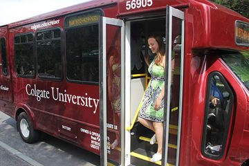 A photo of a student getting off of a new Colgate shuttle bus.