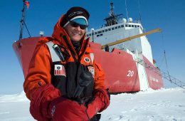 Elizabeth Arnold ’82 standing on ice in front of a ship