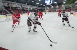 Colgate men's hockey player reaches out for puck in game against Cornell