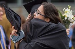 Graduates hug after commencement 2018