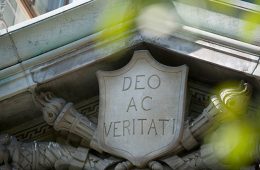 An image of a stone carving with the motto, "Deo Ac Veritati"